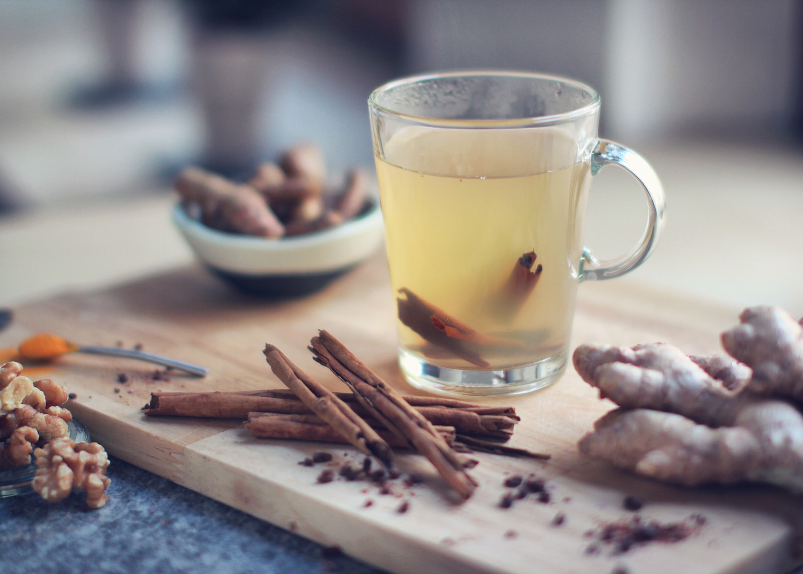 clear glass mug with yellow liquid on brown wooden chopping board